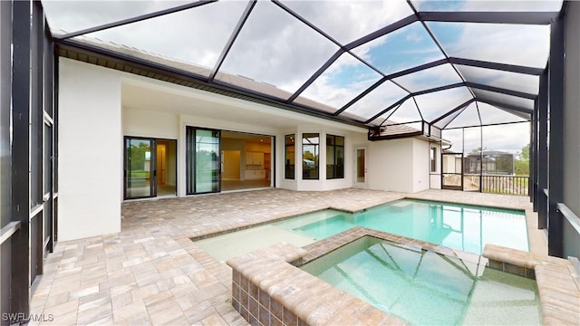 view of pool featuring an in ground hot tub, a patio, and glass enclosure