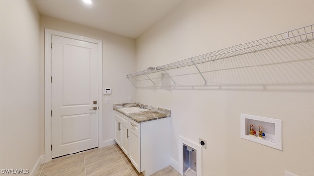 washroom with electric dryer hookup, cabinets, sink, washer hookup, and light tile patterned flooring