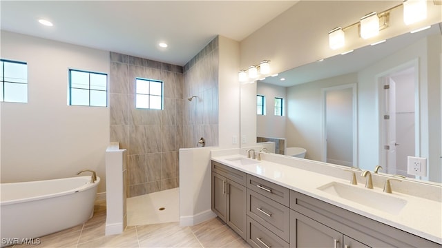 bathroom featuring vanity, tile patterned flooring, and plus walk in shower