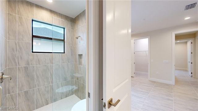 bathroom featuring tile patterned flooring and a tile shower