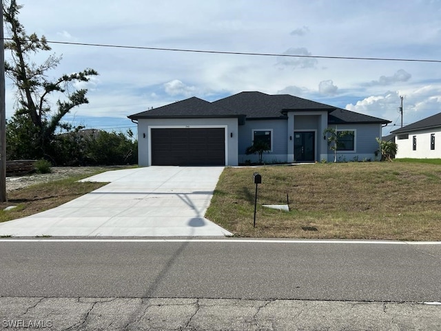 view of front of home with a front yard and a garage