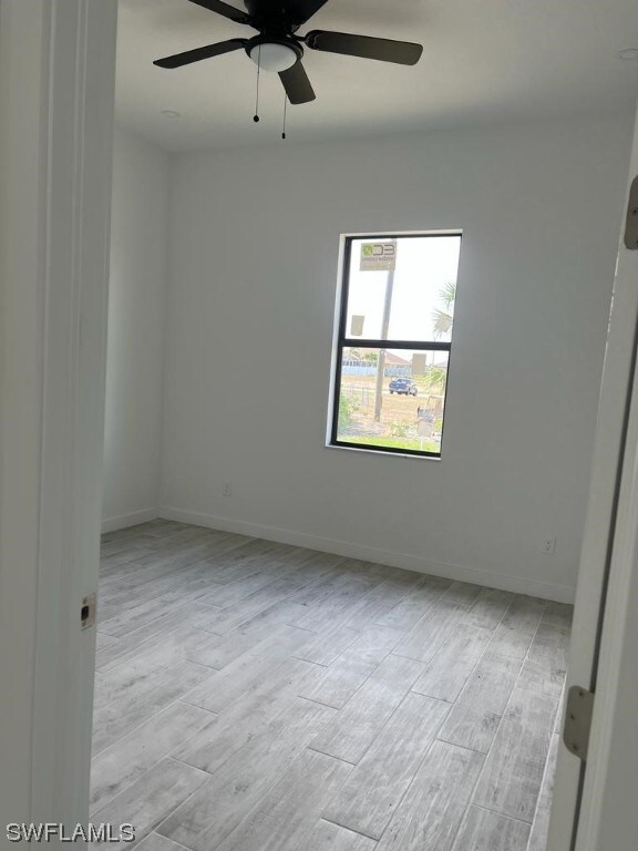 spare room featuring light hardwood / wood-style floors and ceiling fan