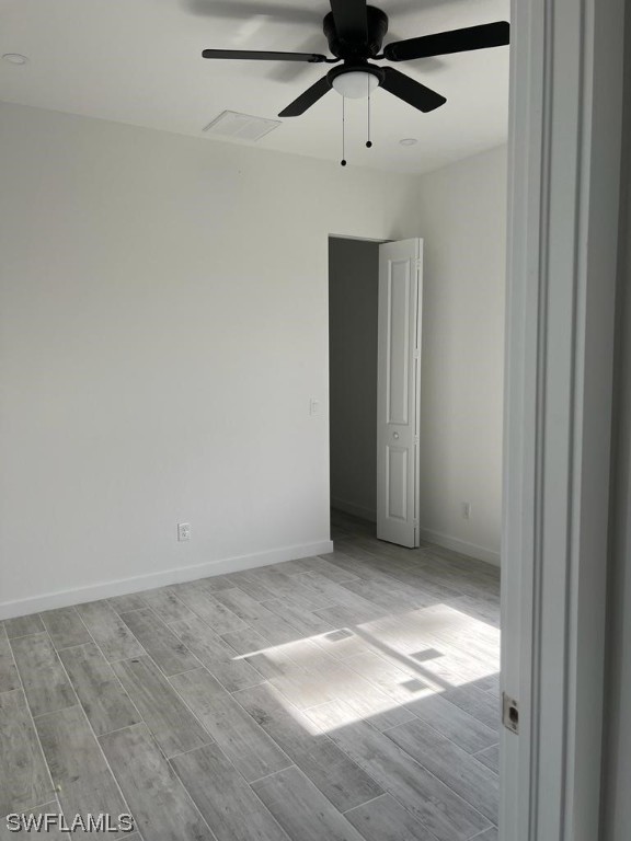 unfurnished room featuring ceiling fan and light hardwood / wood-style flooring