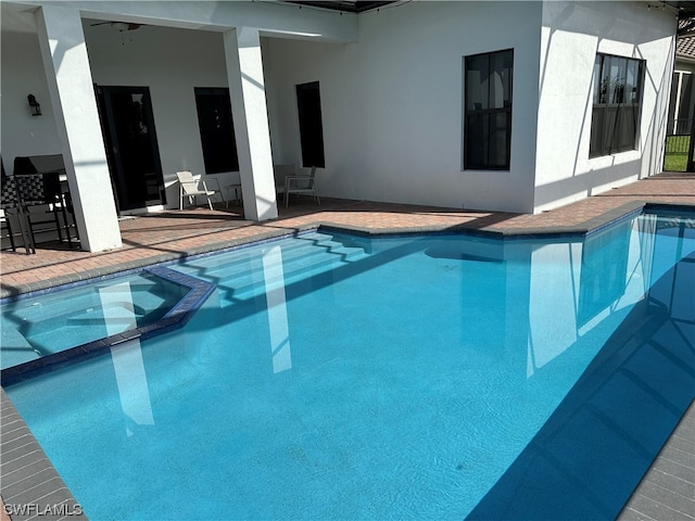 view of pool with a patio area and an in ground hot tub