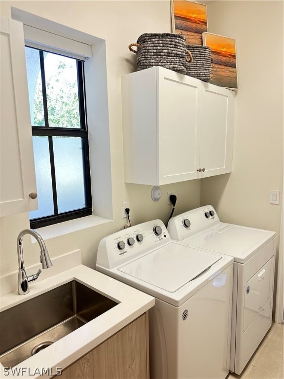 washroom featuring hookup for an electric dryer, sink, cabinets, and washer and clothes dryer