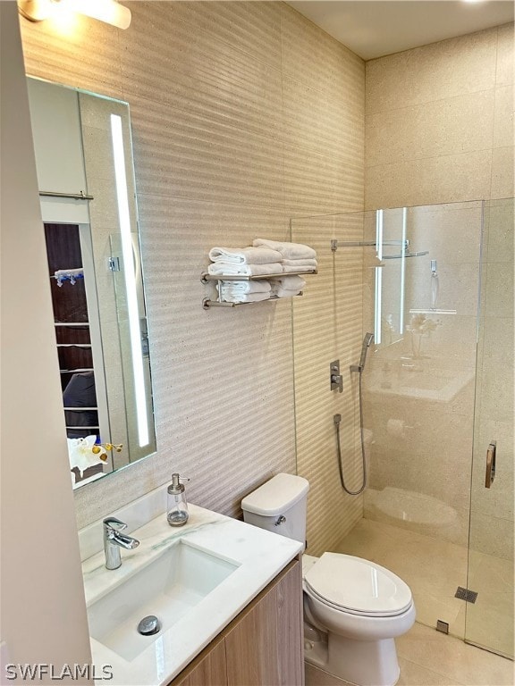 bathroom with vanity, a shower with shower door, and toilet