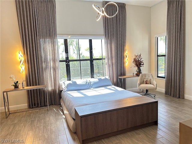 bedroom with hardwood / wood-style flooring and a towering ceiling