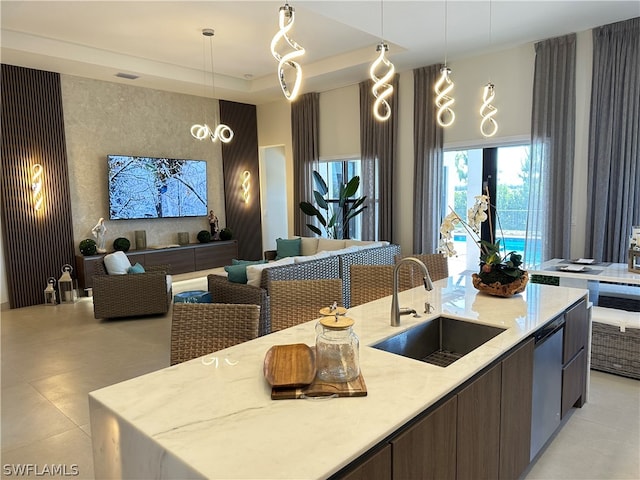 kitchen with pendant lighting, a kitchen island with sink, and sink