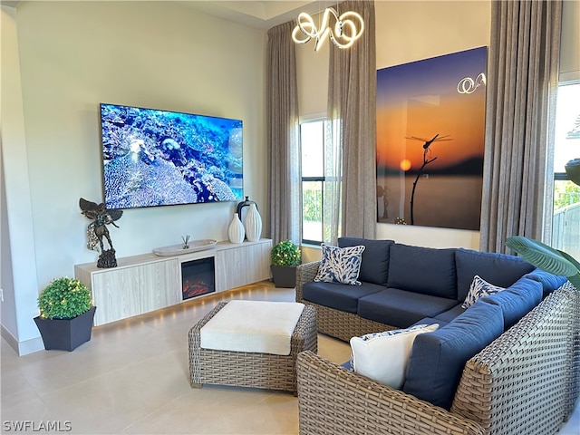 living room featuring a wealth of natural light, a notable chandelier, and tile floors