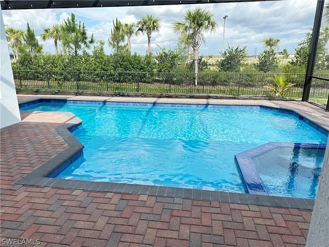 view of swimming pool with an in ground hot tub