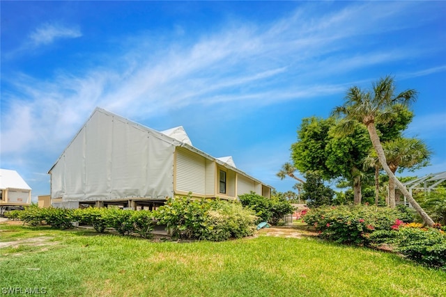 view of side of home with a yard