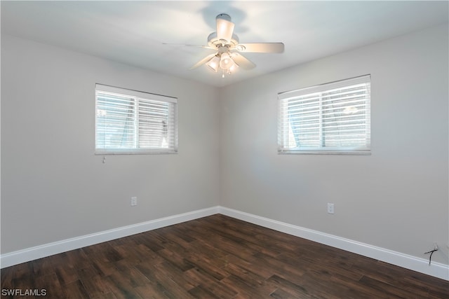 empty room with plenty of natural light, dark hardwood / wood-style floors, and ceiling fan