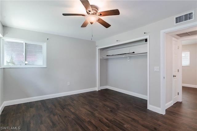 unfurnished bedroom featuring multiple windows, ceiling fan, a closet, and dark wood-type flooring