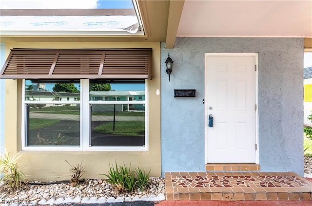 view of exterior entry featuring a balcony