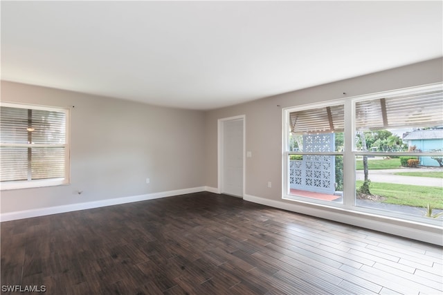 unfurnished room with dark hardwood / wood-style flooring