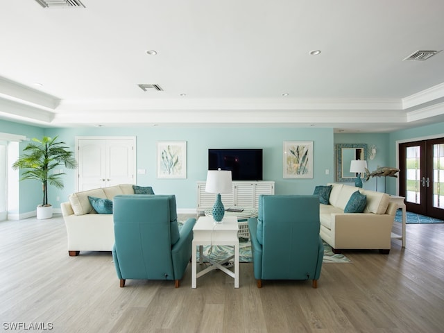 living room with french doors, a wealth of natural light, and light wood-type flooring