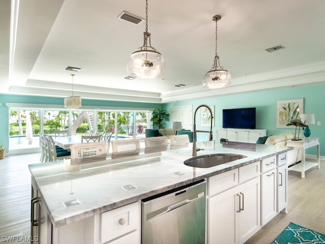 kitchen featuring plenty of natural light, a tray ceiling, dishwasher, and sink