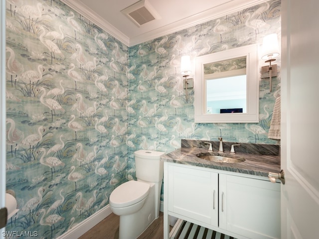 bathroom featuring hardwood / wood-style flooring, vanity, toilet, and ornamental molding