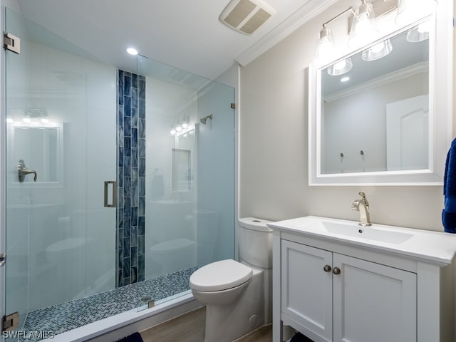 bathroom featuring vanity with extensive cabinet space, toilet, ornamental molding, and a shower with door