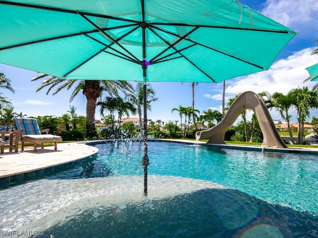 view of pool with a patio area and a water slide