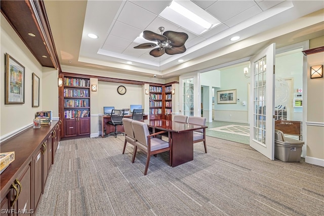 dining space with french doors, ceiling fan, a raised ceiling, and carpet floors