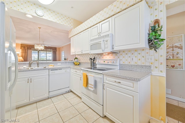 kitchen featuring light tile flooring, white appliances, and white cabinetry