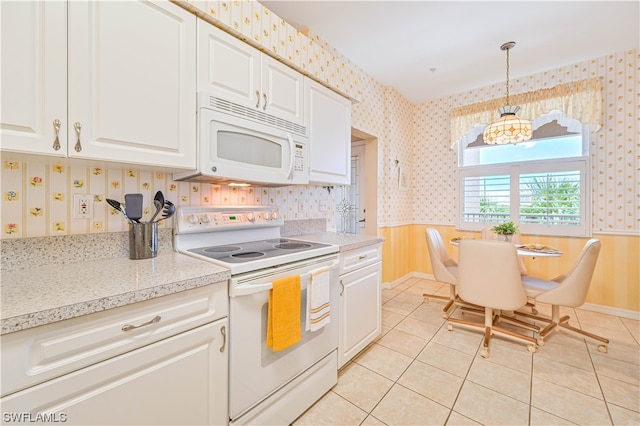 kitchen with white cabinets, white appliances, light tile floors, and pendant lighting