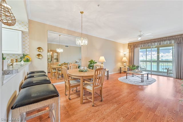 dining room featuring ornamental molding, ceiling fan with notable chandelier, and light wood-type flooring