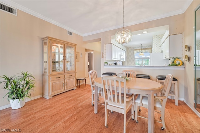 dining space featuring a notable chandelier, crown molding, and light hardwood / wood-style floors