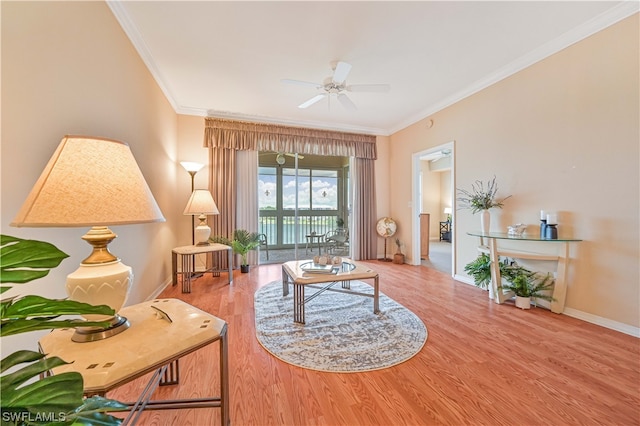 living room with light hardwood / wood-style floors, ceiling fan, and ornamental molding