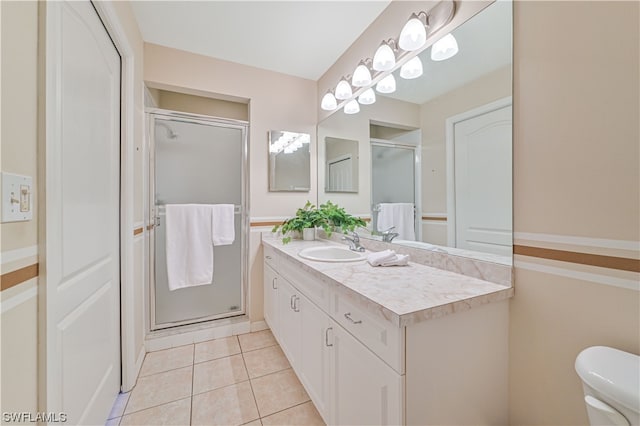 bathroom featuring tile floors, toilet, vanity, and an enclosed shower