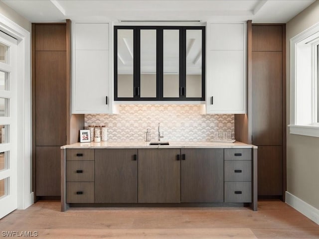 kitchen featuring sink, light hardwood / wood-style flooring, and backsplash