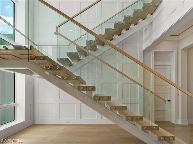 staircase with hardwood / wood-style floors and plenty of natural light