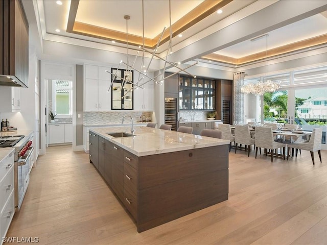 kitchen with white cabinetry, a tray ceiling, and a chandelier