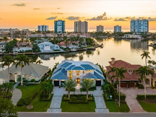 aerial view at dusk featuring a water view