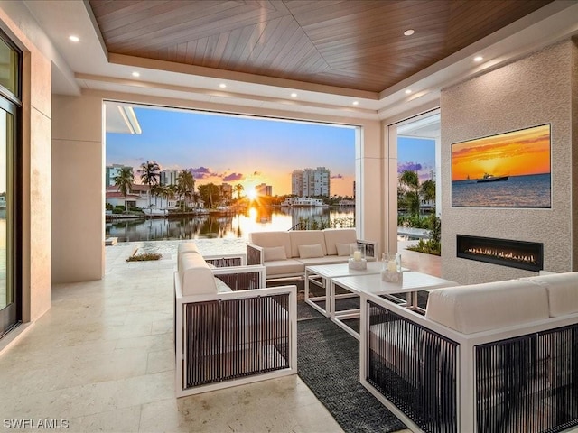 patio terrace at dusk with a water view and an outdoor hangout area