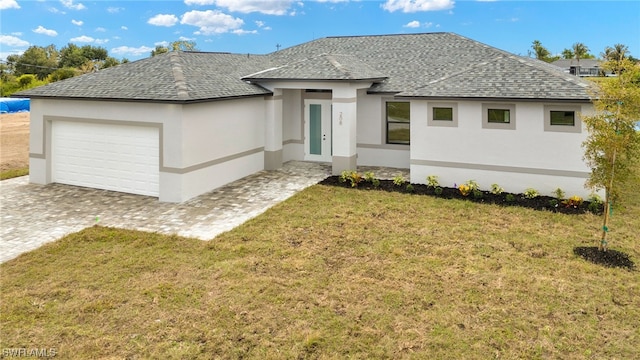 view of front of house featuring a front lawn, decorative driveway, a shingled roof, and an attached garage