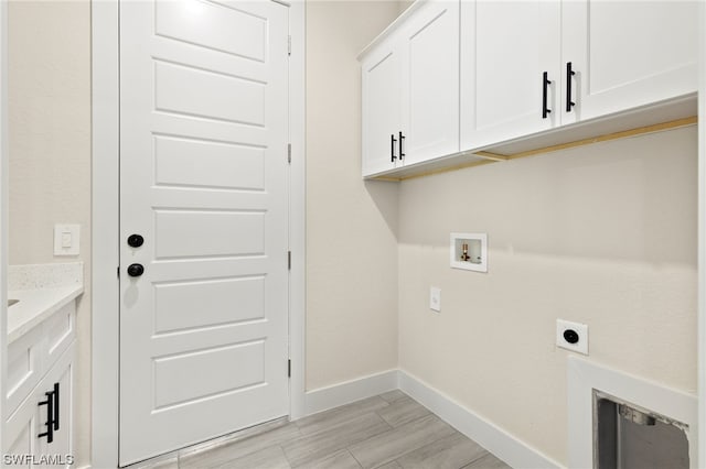 laundry area featuring cabinet space, baseboards, hookup for a washing machine, wood tiled floor, and electric dryer hookup