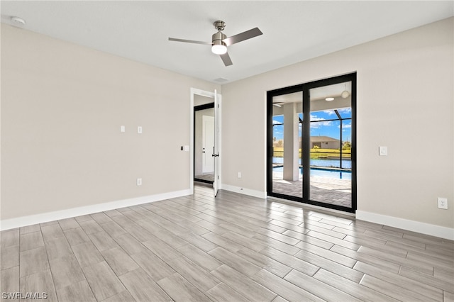 unfurnished room featuring ceiling fan, wood tiled floor, and baseboards