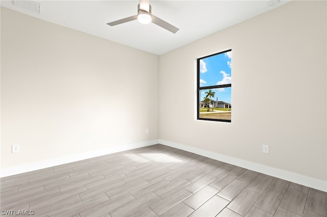 unfurnished room with ceiling fan, wood tiled floor, baseboards, and visible vents