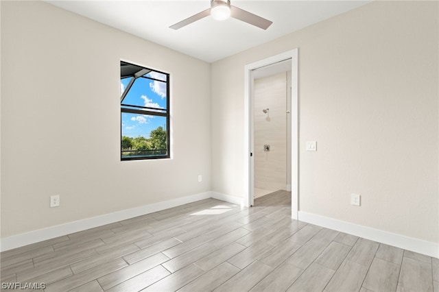 spare room featuring wood tiled floor, baseboards, and ceiling fan