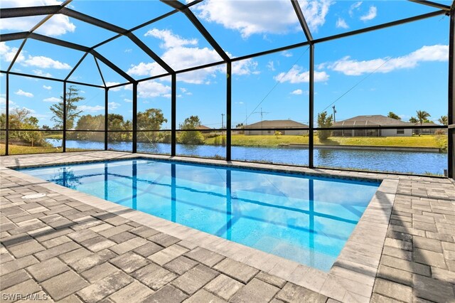 outdoor pool with a lanai, a water view, and a patio