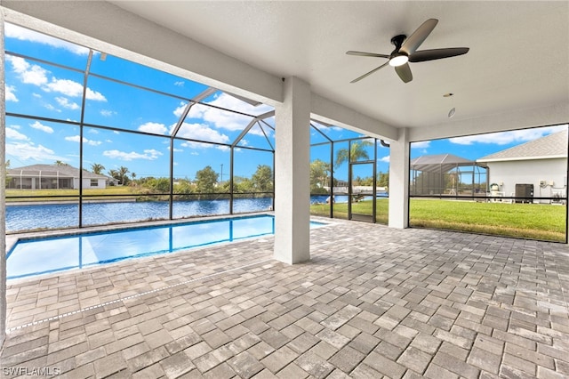 view of swimming pool featuring ceiling fan, a lanai, a water view, a lawn, and a patio area