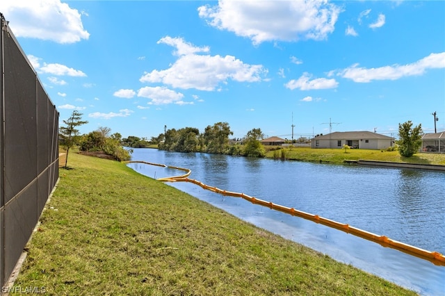 dock area with a water view and a yard