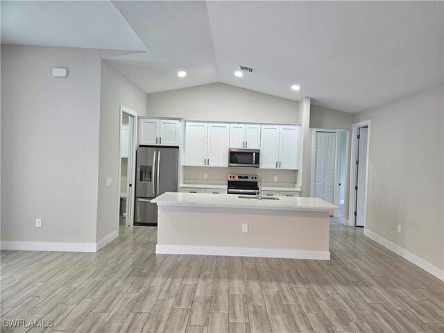 kitchen featuring a kitchen island with sink, white cabinetry, stainless steel appliances, and light countertops