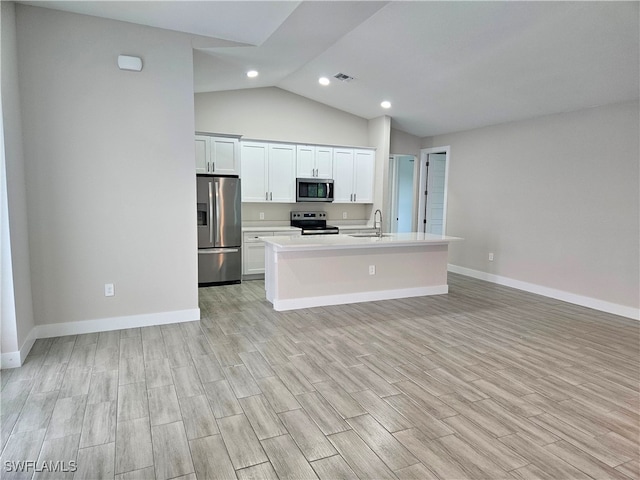 kitchen featuring white cabinets, an island with sink, stainless steel appliances, light countertops, and a sink