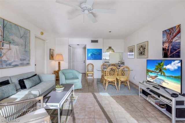 living room featuring light tile patterned floors, visible vents, and ceiling fan