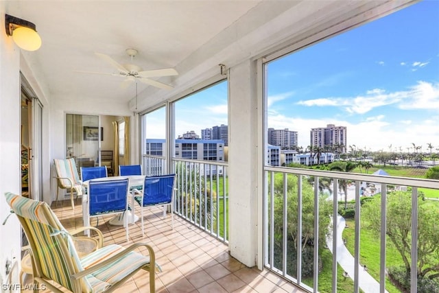 sunroom with a city view and ceiling fan