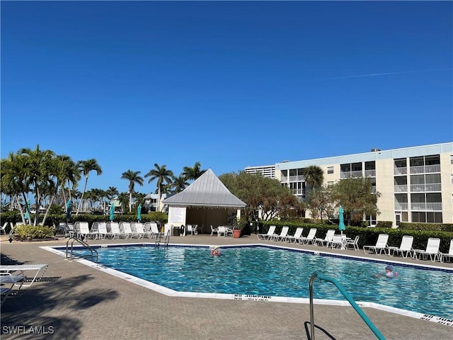 community pool with a patio area and fence