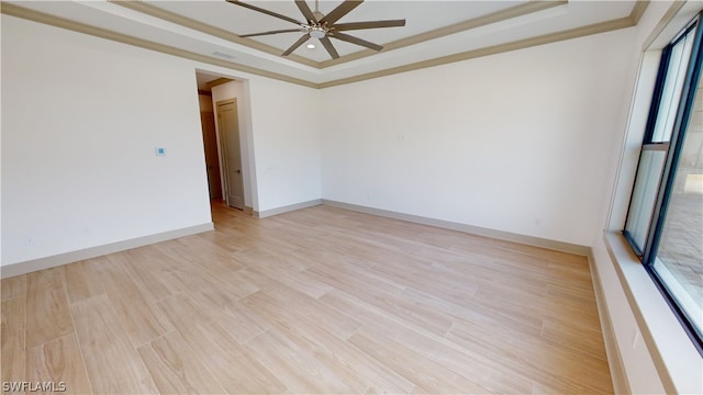 spare room with a raised ceiling, light hardwood / wood-style floors, and ceiling fan